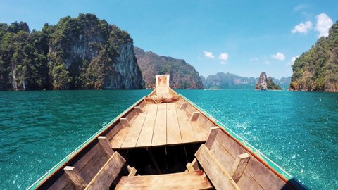 4K view from nose: motorboat sailing through Khao Sok Lake with beautiful mountains ahead