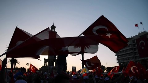 Izmir, Turkey - July 15, 2018: July 15 Day of Democracy in Turkey Izmir. People waving Turkish flags at Konak square in Izmir and in front of the historical clock tower.