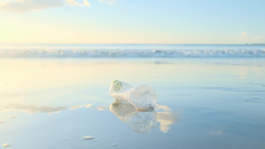 Reduce the use of plastic bottles, recycling the empty used plastic bottle. A discarded plastic bottle is washed up on a sandy beach. Ecology, earth protection, nature conservation, pollution sea. Royalty-Free Stock Footage #1032406580