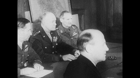 1940s: Dwight D. Eisenhower, Trafford Leigh-Mallory, Bertram Ramsay, Bernard Montgomery and allied generals sit around a conference table. Eisenhower looks at a note and tucks it in his pocket.