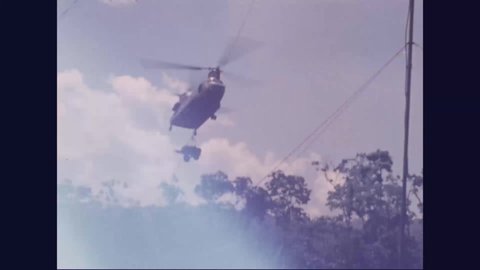 CIRCA 1970 - A CH-47 carries a water trailer to American soldiers in Vietnam.