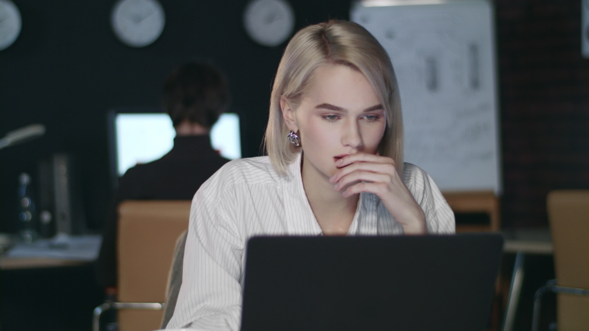 Frustrated business woman working on laptop in late office. Upset woman working late on laptop computer in night office. Sad business woman looking bad business report | Shutterstock HD Video #1032421490