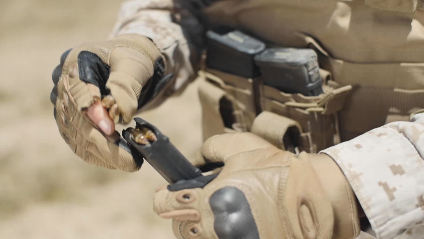 SLOW MOTION: A US Marine positioned in the desert loads bullets in his assault rifle