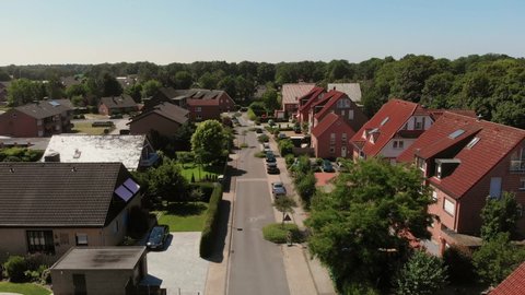 The flight of the camera over the street of a small German city. Houses with red tiled roofs. Germany, Greven. From a bird's eye 4K