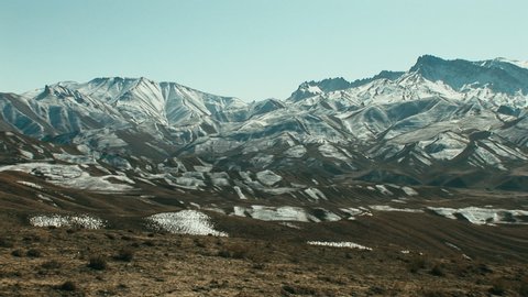 Wide panning shot of the incredible snow capped mountain landscape in Bamyan, Afghanistan 