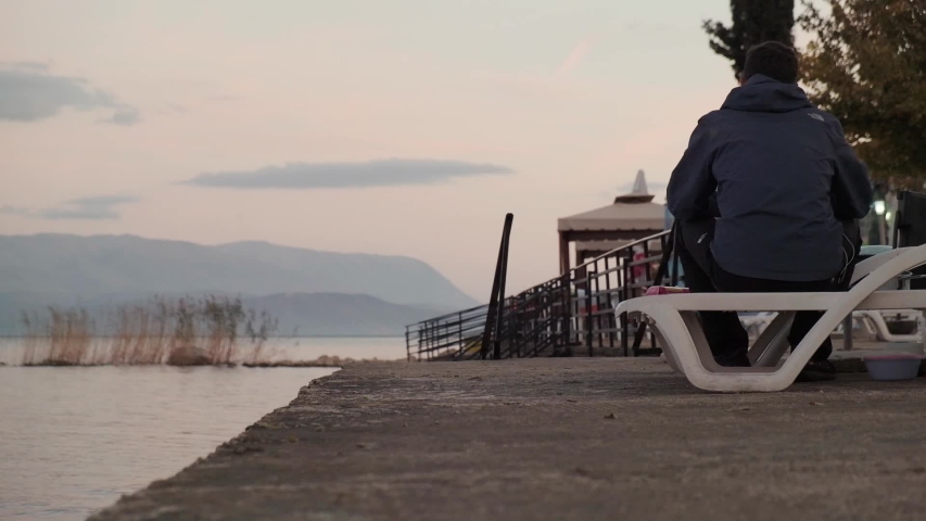 Camping and cooking. Lighting a fire and camp cooker on the beach with beautiful views of the mountain at sunset