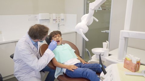 Happy little boy high fiving his dentist after successful dental examination