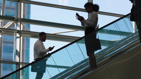 business people on escalators in busy corporate office lobby working nine to five rush 4k footage