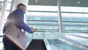 young african american businessman using smartphone on escalator texting checking email messages online successful male executive arriving at work in corporate office building 4k - Powered by Shutterstock - Get 15% off with code: PIKWIZARD15