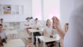 Smart teacher using a transparent tablet augmented reality in the classroom. Close-up of a young woman pressing on a transparent virtual screen for students to wear VR headsets for a futuristic lesson - Powered by Shutterstock - Get 15% off with code: PIKWIZARD15