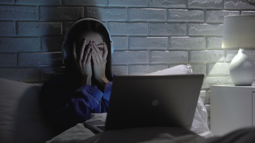 Young female watching scary movie, hiding face in fear, online film service | Shutterstock HD Video #1032468128