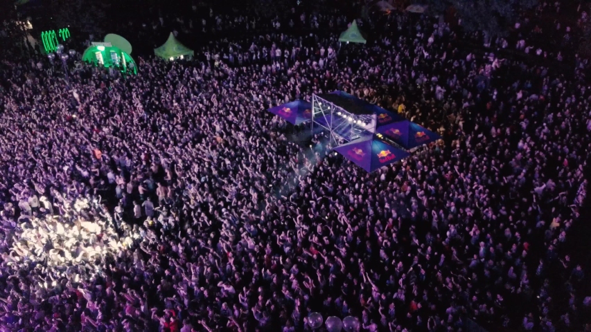 Aerial drone footage of summer music festival crowd partying to popular edm dj set on dance floor. Radio Day Musical Festival event shot from above view flying video camera at night. KYIV-25 MAY,2019