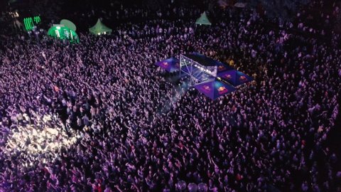 KYIV-25 MAY,2019: Aerial drone footage of summer music festival crowd partying to popular edm dj set on dance floor.Radio Day Festival event shot from above view flying video camera at night