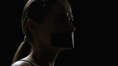 Female tearing off tape, female rights protection, reaction to human trafficking