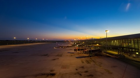 KUALA LUMPUR, MALAYSIA - MAY 2019 : Airplanes taxiing to terminal at Kuala Lumpur International Airport (KLIA), Kuala Lumpur, Malaysia during clear sunset from day to night. Time lapse. 4K. Pan up