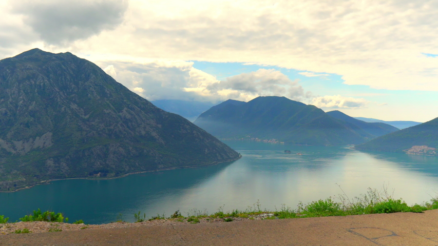 Young Woman In Long Dress Walks Along The Road. Lookinf At Panoramic View Of Sky Mountain And Sea. Nature Concept.