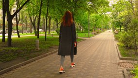 Beautiful Lady Walking Surrounded with Green Trees of Park Road. Girl Going Ahead Turns Head and Smiles. Lifestyle Video