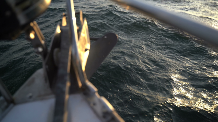 The nose of a sailing yacht on the waves at dawn in the Black Sea