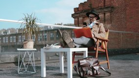 Handsome smiling sociable man in fashion outfit chatting on a smartphone while working on a laptop on his design project on the wonderful terrace over the city. - Powered by Shutterstock - Get 15% off with code: PIKWIZARD15