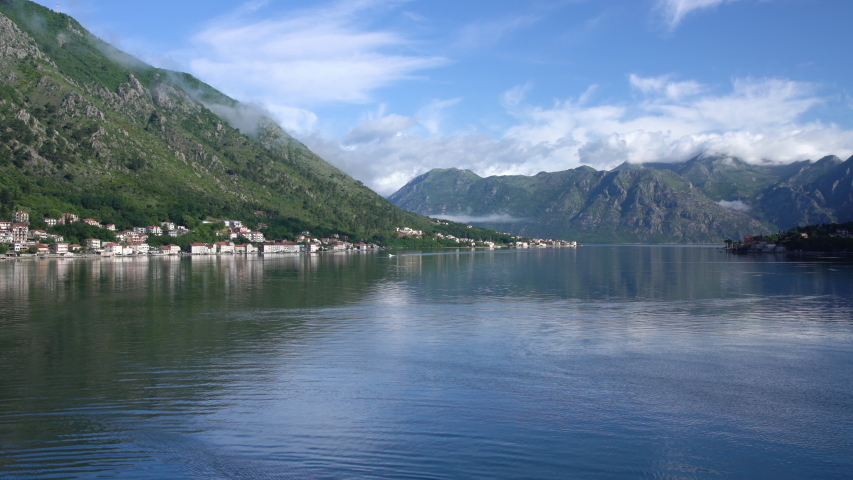 Static view of the Bay of Kotor in Montenegro with a small motor boat coming towards the viewer