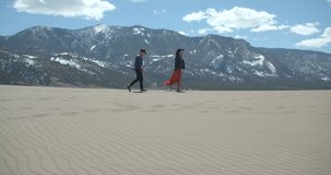Couple Walking Great Sand Dunes in Colorado Mountains