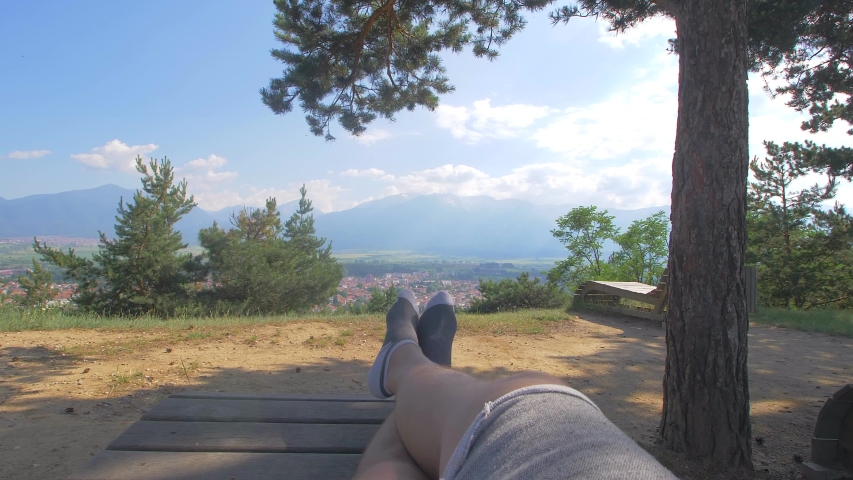 Time to relax. Man lying on a wooden deck chair in the woods