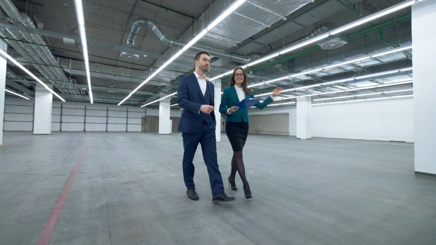 Female real estate agent is guiding a man through an empty property | Shutterstock HD Video #1032509099