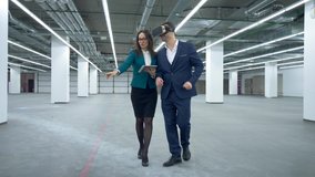 Commercial real estate concept. Businessman in VR-glasses is walking with a female manager along the hall - Powered by Shutterstock - Get 15% off with code: PIKWIZARD15