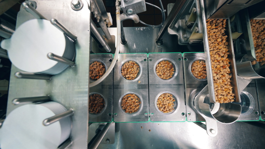 Process of filling containers with wheat crackers at a food factory. Robotic production line