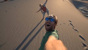 Couple traveling takes selfie picture on sand dunes at sunset. Young couple taking selfies in wester USA. People travel concept. - Powered by Shutterstock - Get 15% off with code: PIKWIZARD15