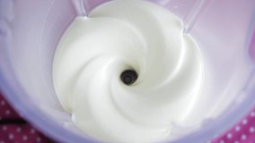 Blender mixing thick white liquid in high speed - Top view