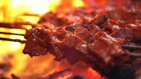 Closeup shot of barbecuing chicken seekh kebab on griller.Grillng/roasting seekh kebab on barbecue griller. Preparing and cooking fiery smokey kebabs.Famous seekh kebab of delhi india.Meat seekh kebab