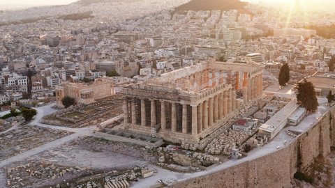 Greece Acropolis city of Athens parthenon, symbol of ancient, aerial view slide from drone on panorama of residential buildings at sunrise summer. Lights sun, lens flare. World Heritage sites. History