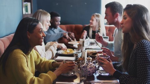 Group Of People Meeting In Restaurant Of Busy Traditional English Pub