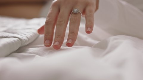 close up womans hand touching bed sheets feeling sensual pleasure enjoying foreplay wearing wedding ring 4k footage