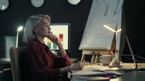 Upset businesswoman writing business reports in night office. Overworked business woman tearing paper at workplace. Stressed woman sitting in front of computer at late work