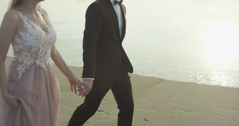 Young husband and wife walking on the beach.