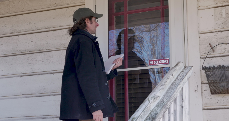 Persistent, determined, man keeps knocking on the front door of a house trying to get the attention of the home owner