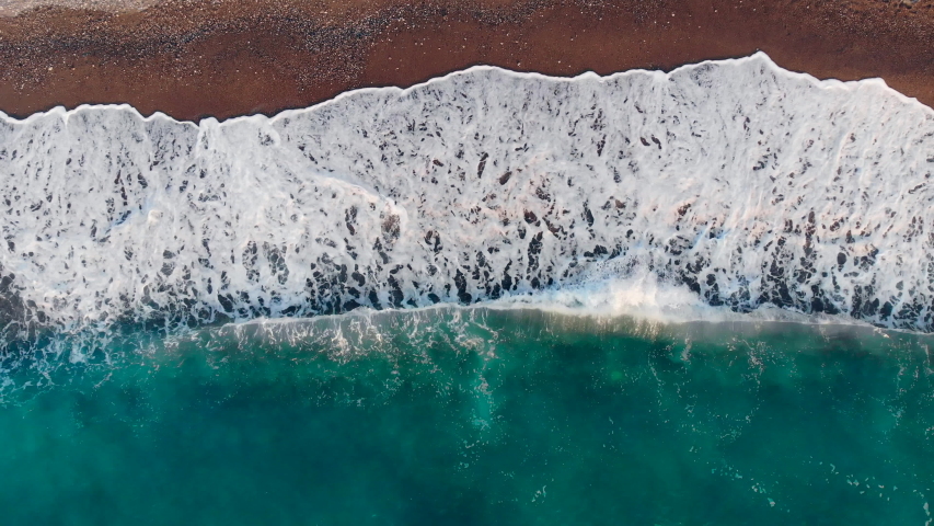 Waves beating on a sand beach. Aerial view.