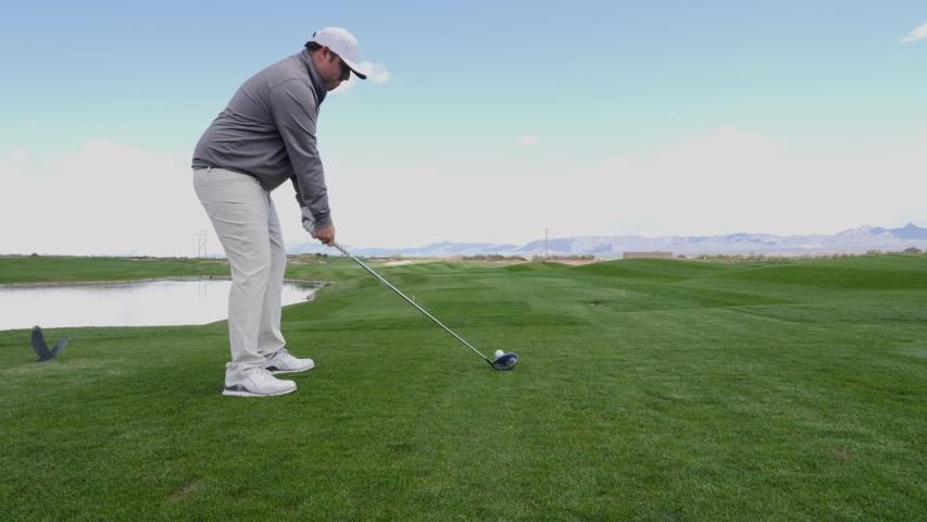 Golfer Tees Off Hole Follow Through. view moves by a golfer teeing off a hole through swing