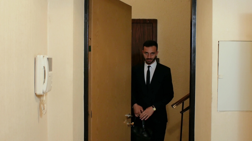 a guy with a beard in a suit and tie is standing outside the door of an apartment and talking. 4k. 4k video - Powered by Shutterstock - Get 15% off with code: PIKWIZARD15