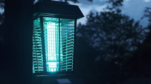 Close up of a bug zapper against night sky. Flat plane. Blurred effects in the background