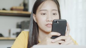 Portrait of a beautiful Asian woman using phone, asia girl chatting with a friend through a video call  at her home 
