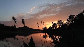Still Video on dramatic sunset over pond water with sky sun and outdoor scenery reflection on lake surface landscape view of summer lake nature dusk in East Lake Wuhan China