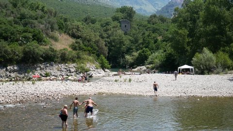 Castelcivita, Campania, Salerno, Italy - June 23 2019: bathers on the Calore river in summer. People swim and having fun in the river
