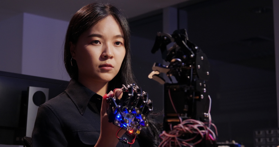 Asian testing cyborg hand at control room. Female doing her robot project she testing sensor signal. Technology and innovation concept. | Shutterstock HD Video #1032581630