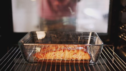 View Looking Out From Inside Oven As Man Cooks Oven Baked Salmon Stockvideó
