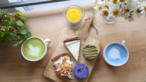Top View Of Trendy Plant-Based Food - Blue And Green Matcha Latte And Raw Vegan Cakes. Video Stok