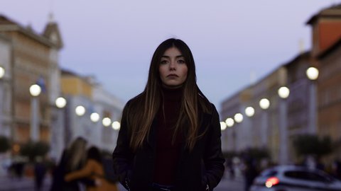Close up portrait of attractive, fashionable, and serious brunette  woman with long hair confidently walking in St Peter's Square in the Vatican