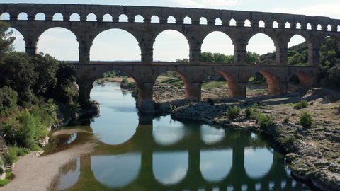 Aerial shot passing through the Pont du Gard arches sunny day  Stock Video